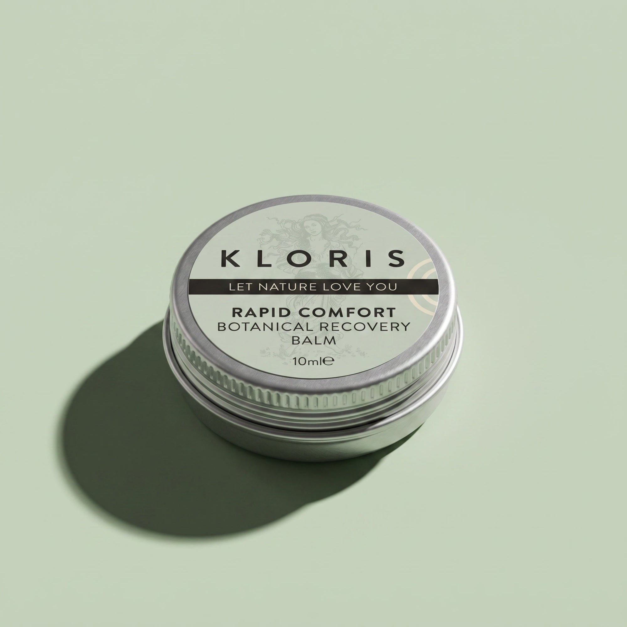A round silver metal tin of Kloris Rapid Comfort Botanical Recovery Balm, set against a solid sage green background with a soft shadow.